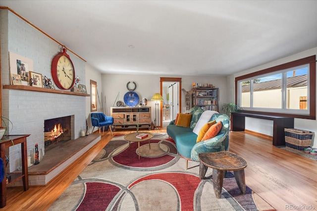 living room with light wood-type flooring and a brick fireplace