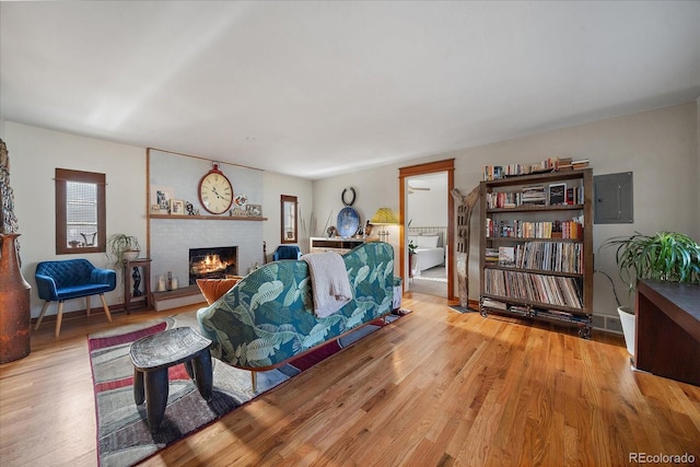 living room with wood-type flooring, a fireplace, and electric panel