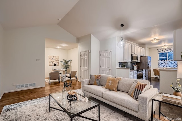 living room with lofted ceiling, dark wood-style floors, visible vents, and baseboards