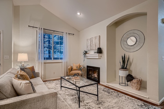 living room with lofted ceiling, wood finished floors, a glass covered fireplace, and recessed lighting