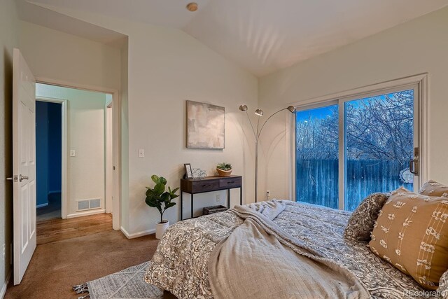 carpeted bedroom featuring lofted ceiling and visible vents