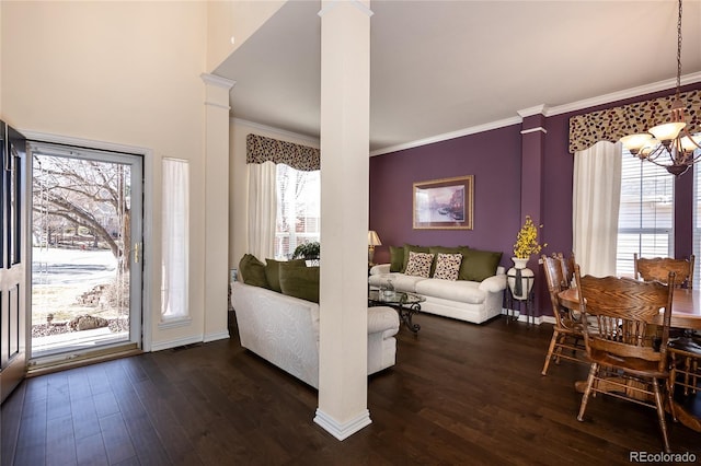 living room with a notable chandelier, dark wood-style flooring, baseboards, decorative columns, and crown molding