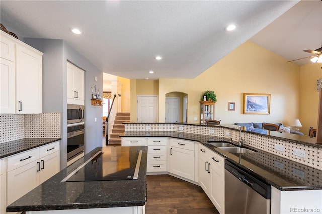 kitchen with stainless steel appliances, dark wood-type flooring, a sink, a large island, and decorative backsplash