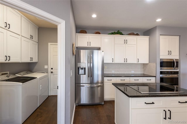 kitchen featuring washing machine and dryer, decorative backsplash, stainless steel appliances, and dark wood-type flooring