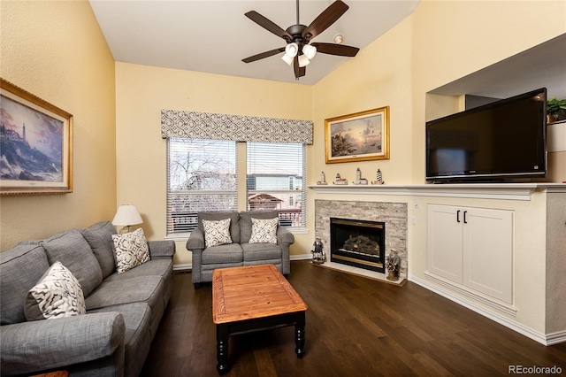 living area with dark wood-type flooring, lofted ceiling, a fireplace, and ceiling fan