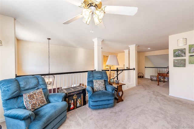 living area featuring ceiling fan, carpet flooring, an upstairs landing, and ornate columns