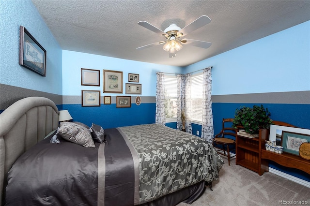 carpeted bedroom featuring a textured ceiling and ceiling fan
