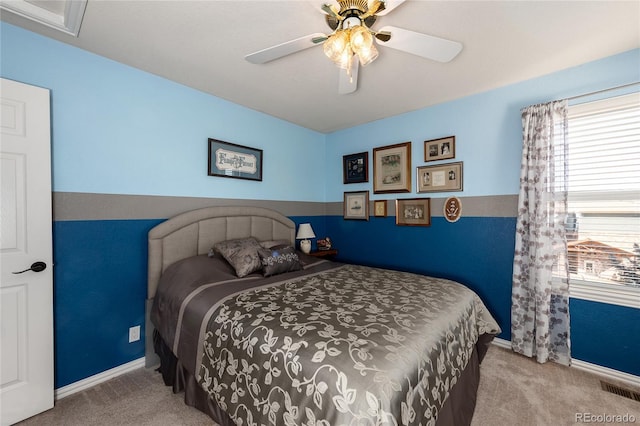 carpeted bedroom featuring ceiling fan, visible vents, and baseboards
