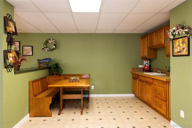 dining area with baseboards and a drop ceiling