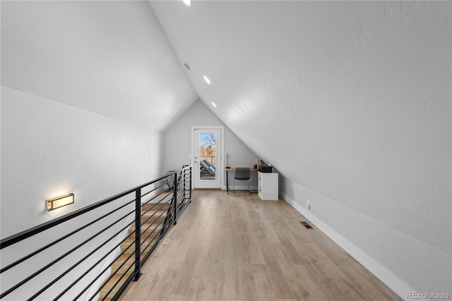 additional living space with lofted ceiling and light hardwood / wood-style flooring