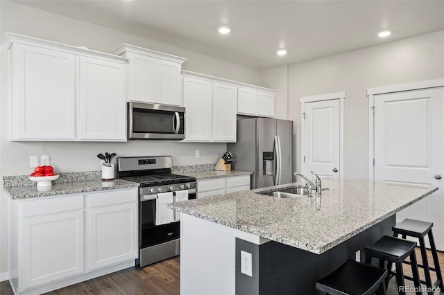 kitchen featuring sink, dark wood-type flooring, a center island with sink, white cabinets, and appliances with stainless steel finishes