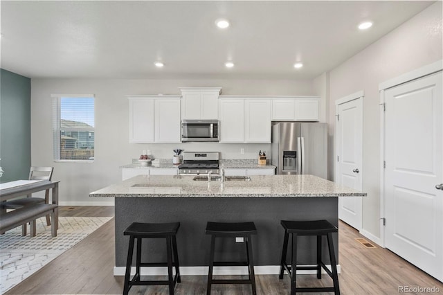 kitchen featuring white cabinetry, a kitchen island with sink, and appliances with stainless steel finishes