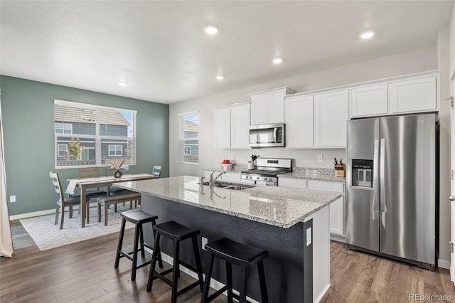 kitchen with sink, stainless steel appliances, dark hardwood / wood-style flooring, an island with sink, and white cabinets