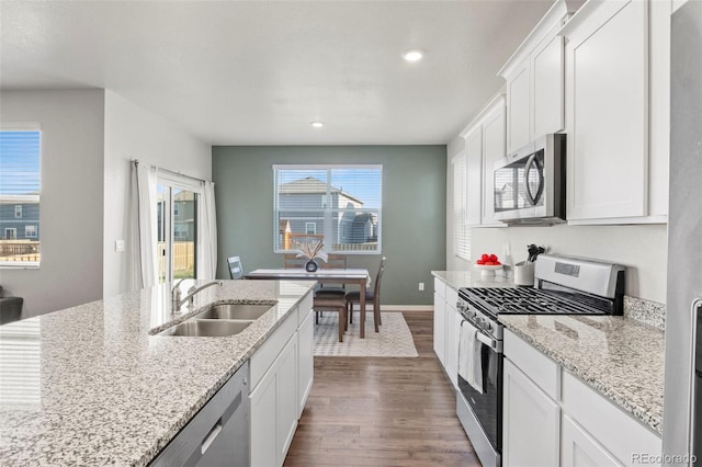 kitchen featuring appliances with stainless steel finishes, white cabinetry, and sink