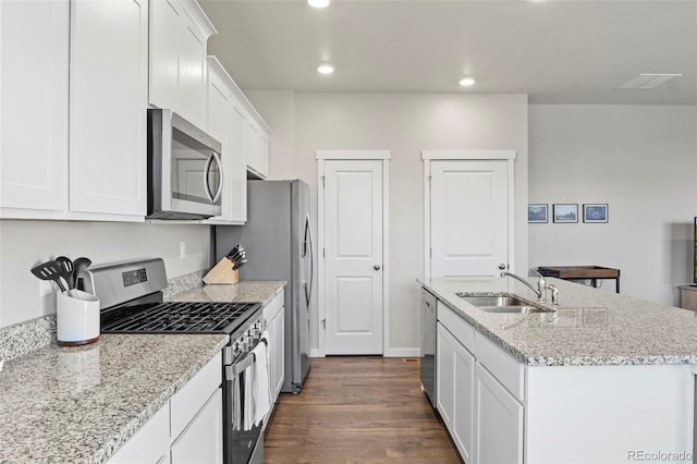 kitchen with sink, light stone counters, an island with sink, white cabinets, and appliances with stainless steel finishes