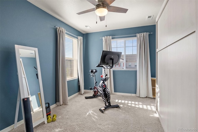 exercise area featuring ceiling fan, a healthy amount of sunlight, and light colored carpet