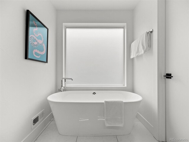 3715 Kalamath St, Denver, CO 80211 - full bathroom featuring baseboards, marble look tiles, and a freestanding bath
