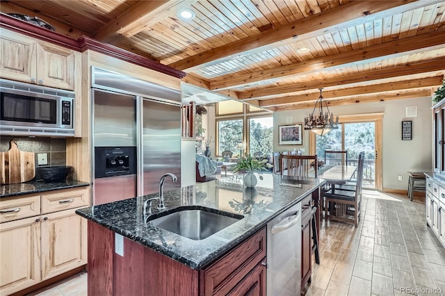 9659 S Turkey Creek Rd, Morrison, CO 80465 - kitchen featuring built in appliances, a sink, wood ceiling with exposed beams, a center island with sink, and pendant lighting