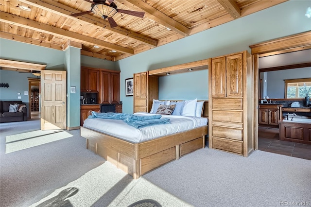 9659 S Turkey Creek Rd, Morrison, CO 80465 - carpeted bedroom with wooden ceiling with exposed beams, a sink, and ensuite bathroom
