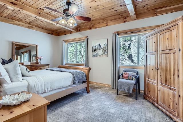 9659 S Turkey Creek Rd, Morrison, CO 80465 - bedroom featuring wooden ceiling with exposed beams, multiple windows, baseboards, light carpet, and a ceiling fan