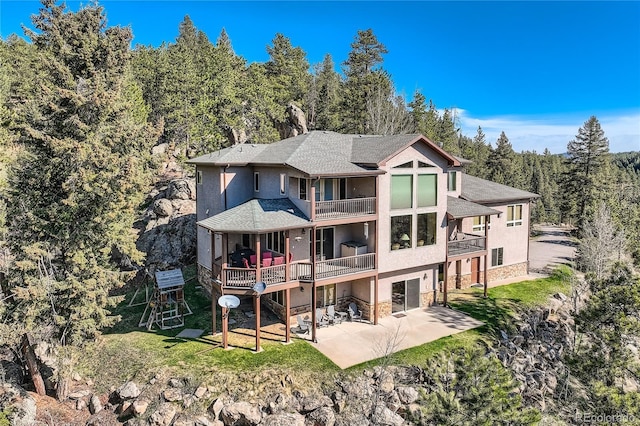 9659 S Turkey Creek Rd, Morrison, CO 80465 - rear view of property featuring a balcony, a patio area, stone siding, and stucco siding