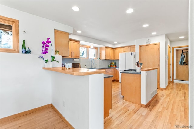 597 Pine Glade Rd, Nederland, CO 80466 - kitchen featuring a sink, recessed lighting, a peninsula, light wood-style floors, and baseboards