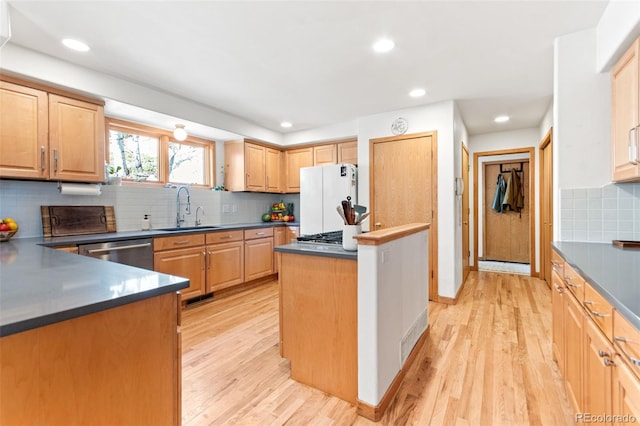 597 Pine Glade Rd, Nederland, CO 80466 - kitchen with a sink, freestanding refrigerator, dishwasher, backsplash, and light wood finished floors