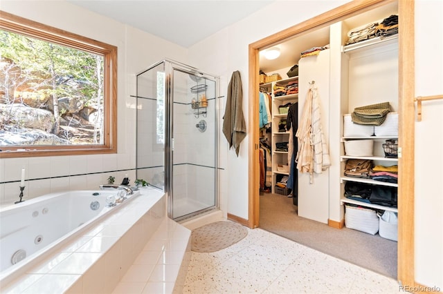 597 Pine Glade Rd, Nederland, CO 80466 - full bath featuring a shower stall, baseboards, a jetted tub, and a spacious closet
