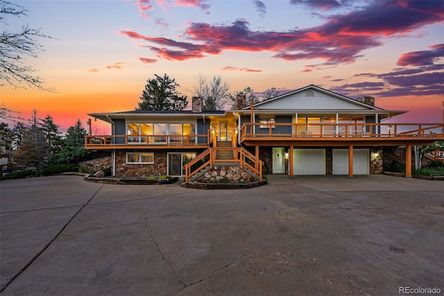 8090 Newton St, Westminster, CO 80031 - view of front of house with curved driveway, stairs, stone siding, and an attached garage