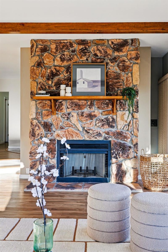 8090 Newton St, Westminster, CO 80031 - detailed view of a stone fireplace, wood finished floors, beamed ceiling, and baseboards