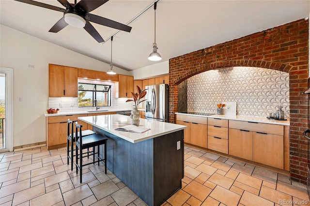 8090 Newton St, Westminster, CO 80031 - kitchen featuring stainless steel fridge, vaulted ceiling, tasteful backsplash, light countertops, and a sink