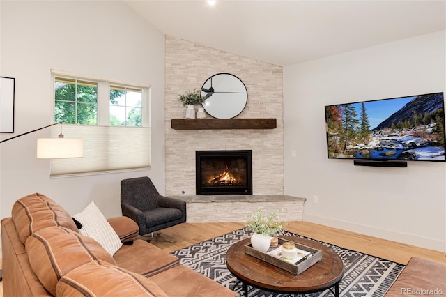 living room with a fireplace, wood finished floors, baseboards, and high vaulted ceiling