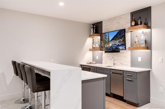4711 S Logan St, Englewood, CO 80113 - indoor wet bar with baseboards, stainless steel dishwasher, and light wood-style floors