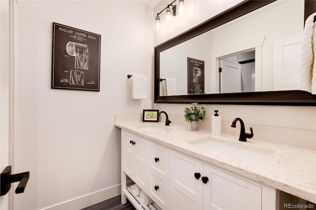 4711 S Logan St, Englewood, CO 80113 - bathroom featuring baseboards, double vanity, and wood finished floors