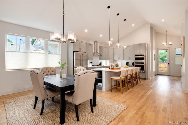 4711 S Logan St, Englewood, CO 80113 - dining area with a chandelier, high vaulted ceiling, healthy amount of natural light, baseboards, and light wood finished floors