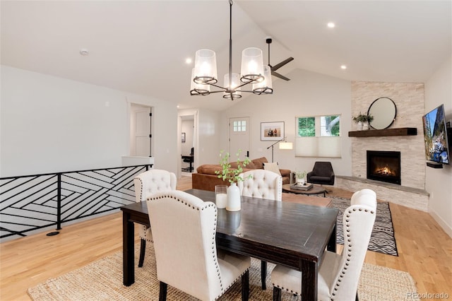 4711 S Logan St, Englewood, CO 80113 - dining space featuring light wood-type flooring, a chandelier, a fireplace, and high vaulted ceiling