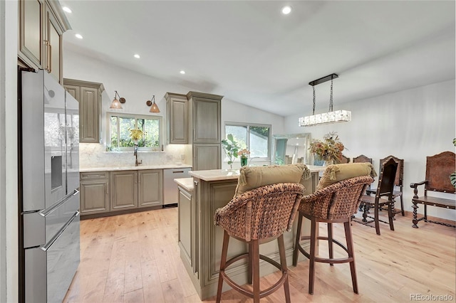 kitchen with light hardwood / wood-style flooring, stainless steel appliances, lofted ceiling, and a kitchen island