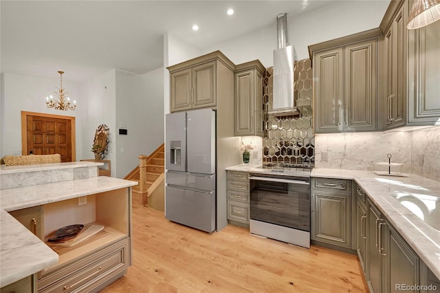 kitchen featuring light stone counters, pendant lighting, light hardwood / wood-style flooring, appliances with stainless steel finishes, and decorative backsplash