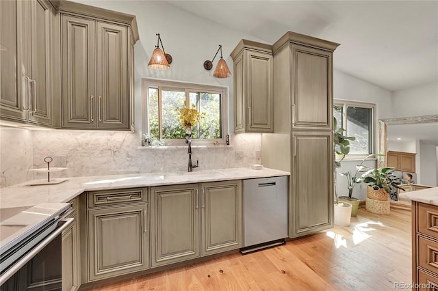 kitchen with tasteful backsplash, sink, lofted ceiling, light hardwood / wood-style flooring, and stainless steel appliances