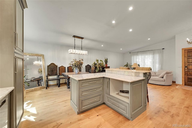 kitchen featuring pendant lighting, a center island, light hardwood / wood-style flooring, gray cabinetry, and light stone countertops