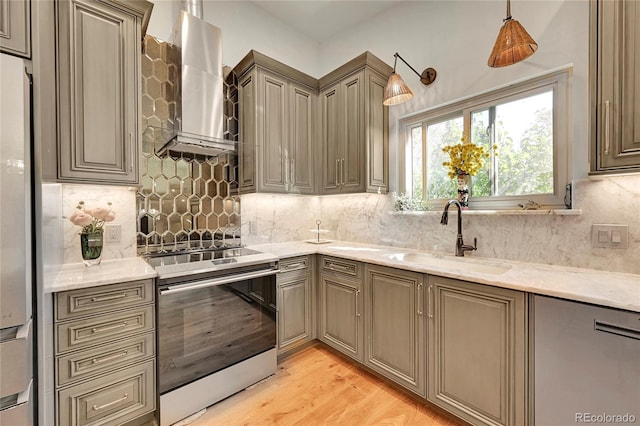 kitchen featuring pendant lighting, light wood-type flooring, sink, electric stove, and wall chimney range hood