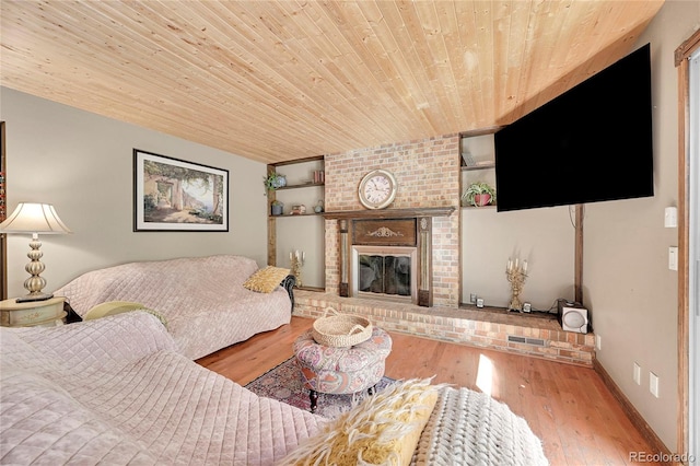 living room featuring wood ceiling, hardwood / wood-style flooring, and a fireplace