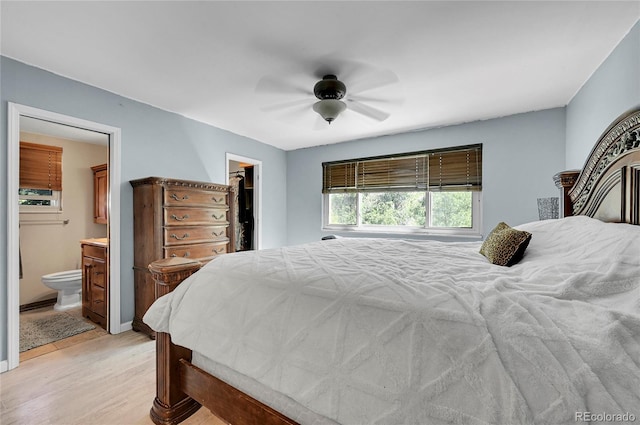 bedroom featuring light wood-type flooring, a closet, a walk in closet, ensuite bathroom, and ceiling fan