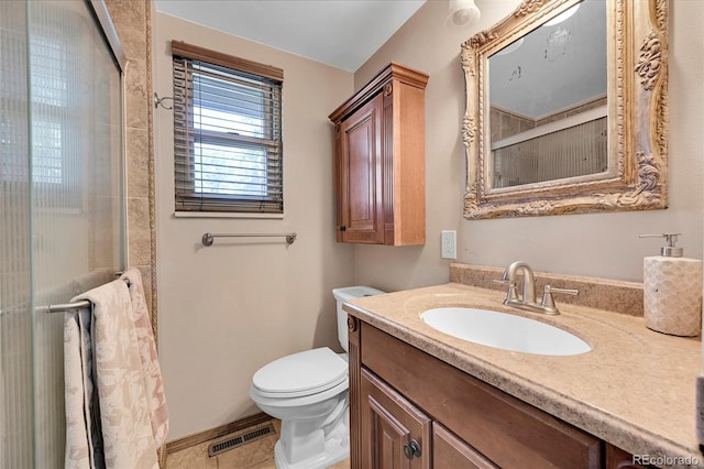 bathroom featuring vanity, tile patterned flooring, toilet, and a shower with door