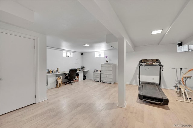 exercise room featuring wood-type flooring and built in desk