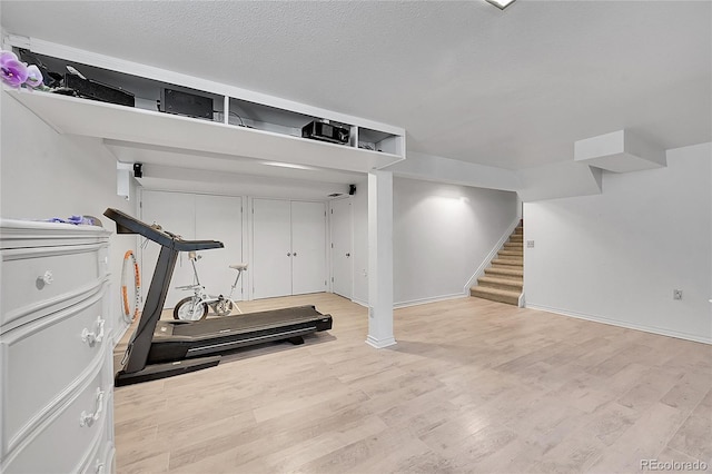 exercise area with a textured ceiling and light hardwood / wood-style flooring