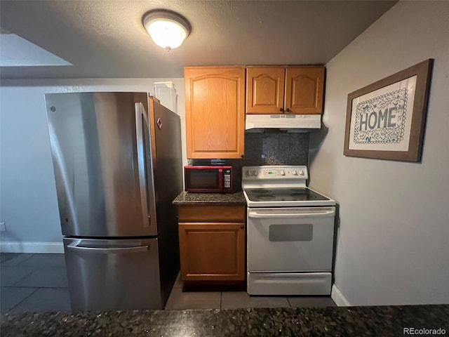 kitchen featuring freestanding refrigerator, white range with electric stovetop, under cabinet range hood, and tile patterned flooring