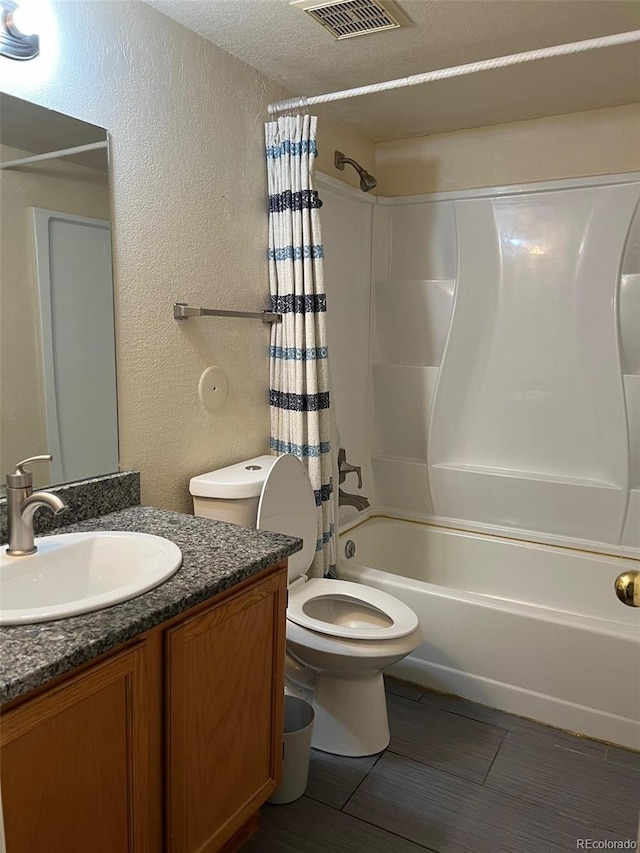 full bathroom with a textured wall, toilet, shower / bath combo, vanity, and a textured ceiling