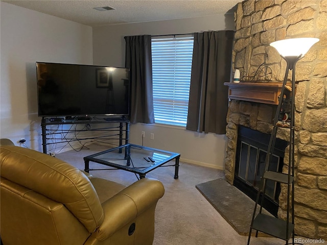 carpeted living area featuring a fireplace and a textured ceiling