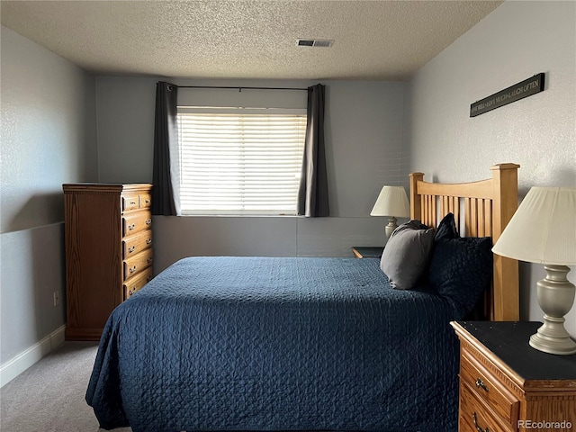 bedroom with light carpet, a textured ceiling, and baseboards